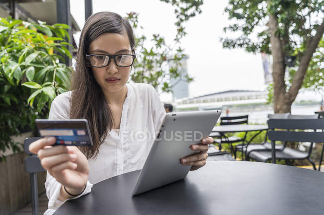 Young beautiful asian woman making transaction with tablet — Stock Photo
