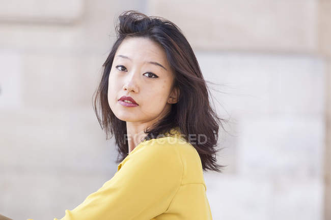 Porträt einer sexy und exotischen jungen Chinesin im gelben Hemd, die mit geschlossenen Augen nach oben schaut — Stockfoto