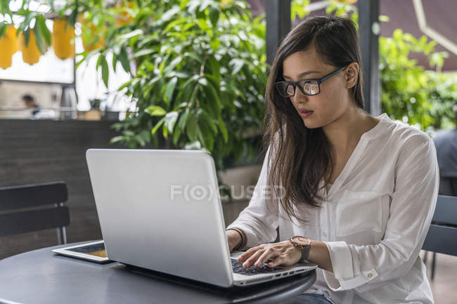 Jovem bela mulher asiática usando laptop — Fotografia de Stock