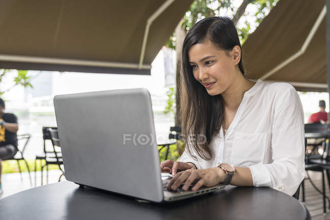 Joven hermosa mujer asiática usando laptop - foto de stock