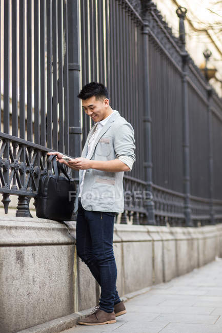 Homme d'affaires chinois textos au téléphone dans la rue à Madrid, Espagne — Photo de stock