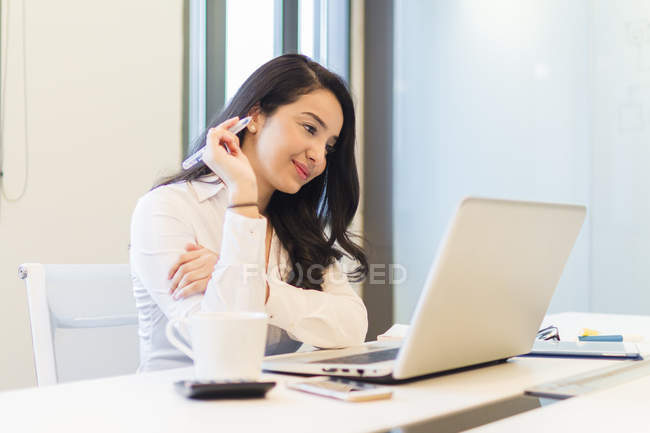 Jeune femme travaillant dans un bureau moderne — Photo de stock