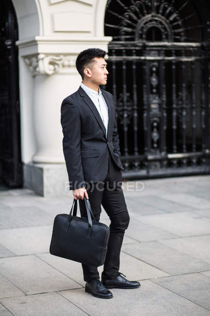 Homme d'affaires chinois intelligent debout dans la rue à Madrid, Espagne — Photo de stock