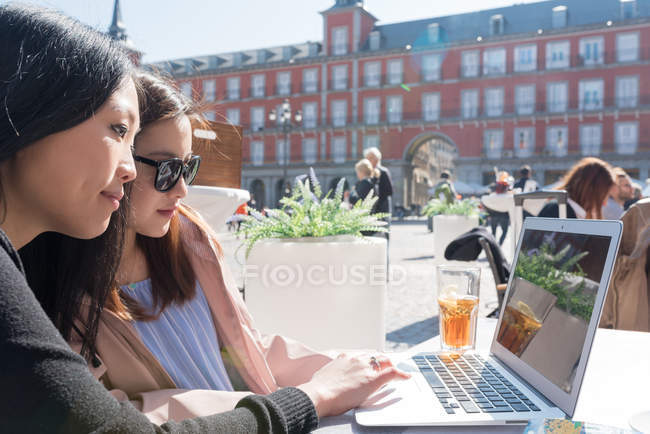 Mulheres asiáticas em um café usando laptop em Madrid, Espanha — Fotografia de Stock