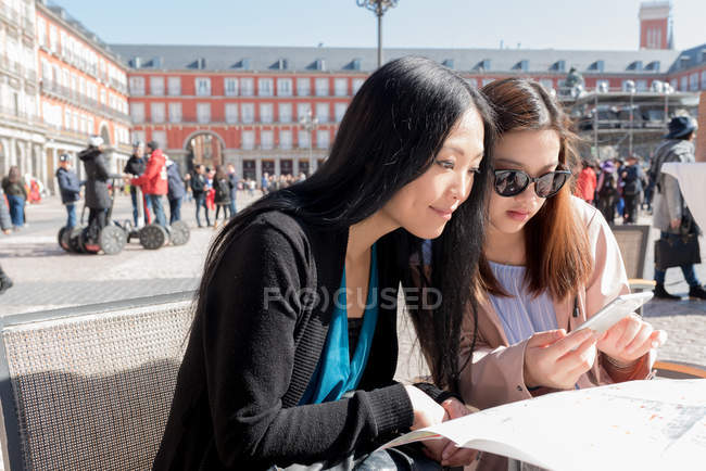 Mulheres asiáticas em um café usando o mapa em Madrid, Espanha — Fotografia de Stock
