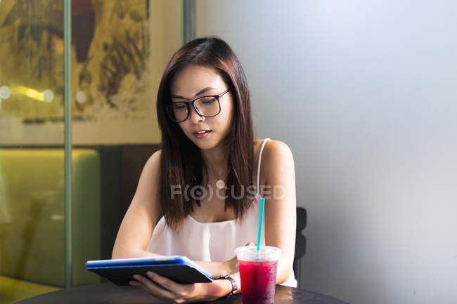 Schön asiatische Mädchen mit tablet in cafe — Stockfoto