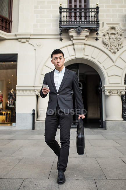 Empresario chino caminando por la calle en Madrid, España - foto de stock