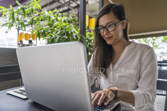 Giovane bella donna asiatica utilizzando laptop — Foto stock
