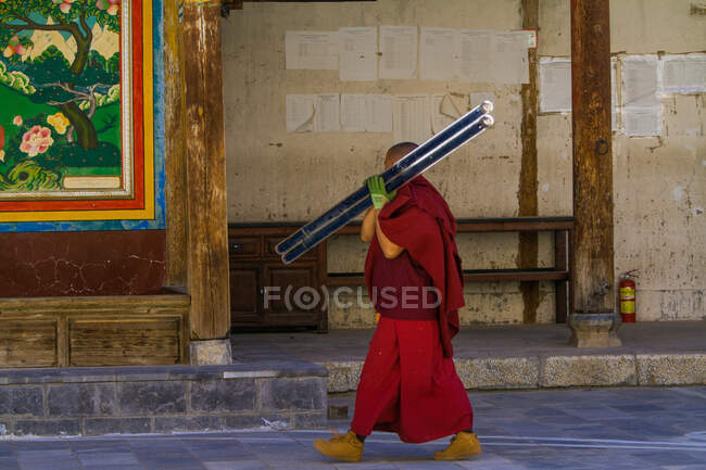 Monje tibetano trabajando en el Monasterio de Dongzhulin - foto de stock
