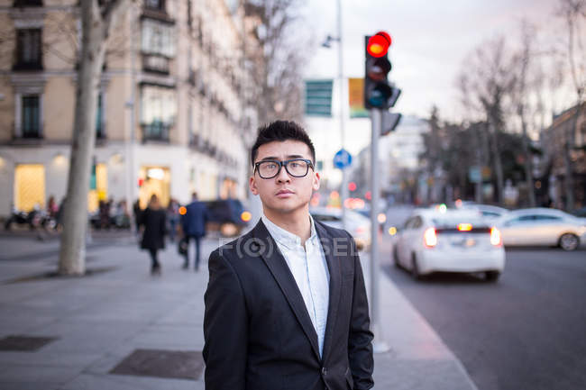 Retrato de um empresário chinês inteligente em pé na rua Serrano em Madrid, Espanha — Fotografia de Stock