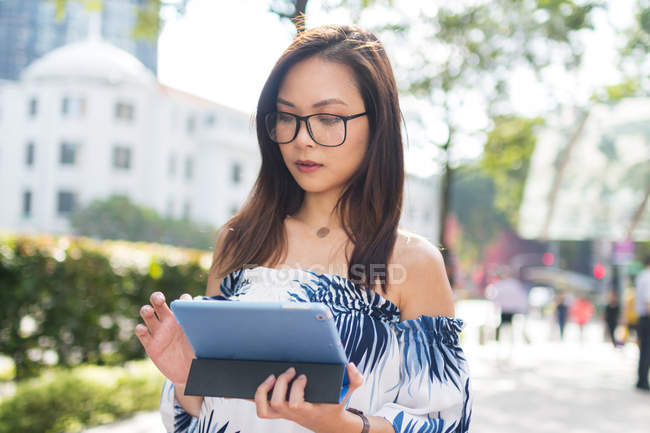 Menina asiática bonita com tablet na rua — Fotografia de Stock