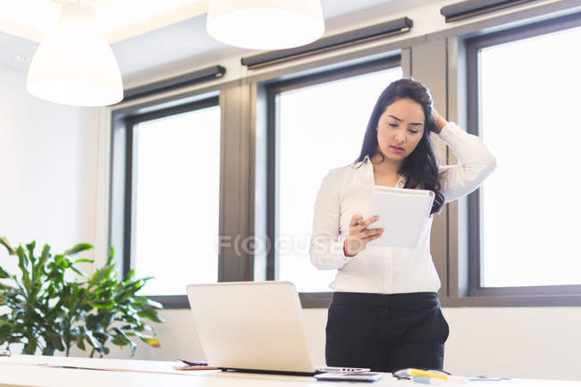 Наголошена молода жінка працює в сучасному офісі — стокове фото