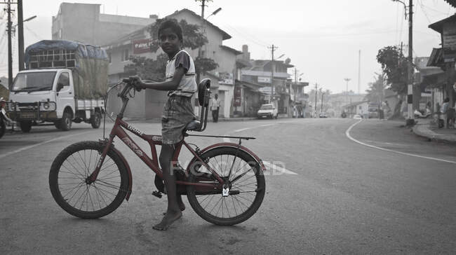 Indischer Junge fährt mit dem Fahrrad durch das Dorf Mundgod — Stockfoto