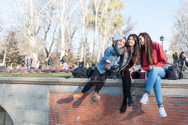 Amigos filipinos mujeres tomando fotos y selfies en el Parque del Retiro Madrid - foto de stock
