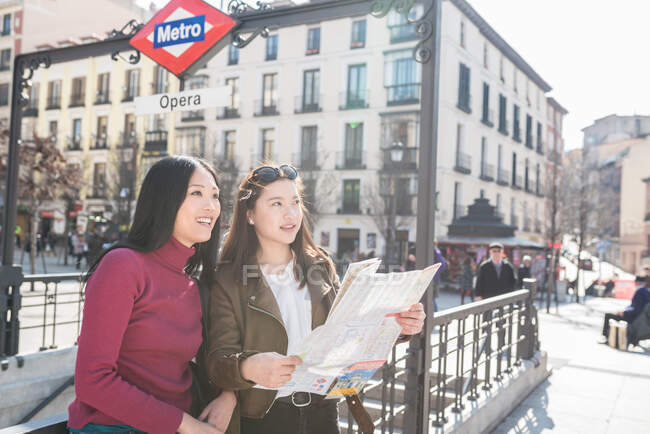 Mujeres asiáticas haciendo turismo en Madrid con mapa - foto de stock