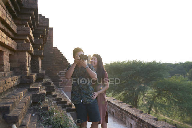Молодая пара делает фотографии вокруг древнего храма Пятадар, Баган, Мьянма — стоковое фото