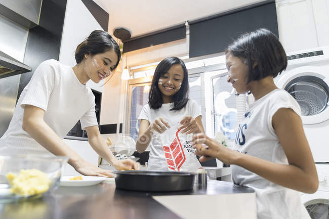 Feliz asiático familia celebrando hari raya en casa y cocinar en cocina - foto de stock