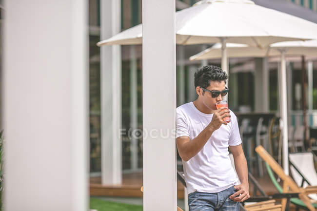 Homem com óculos de sol tendo bebida no hotel — Fotografia de Stock