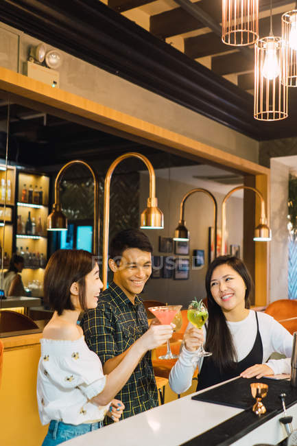 Jeunes amis asiatiques ayant boire dans un bar confortable — Photo de stock