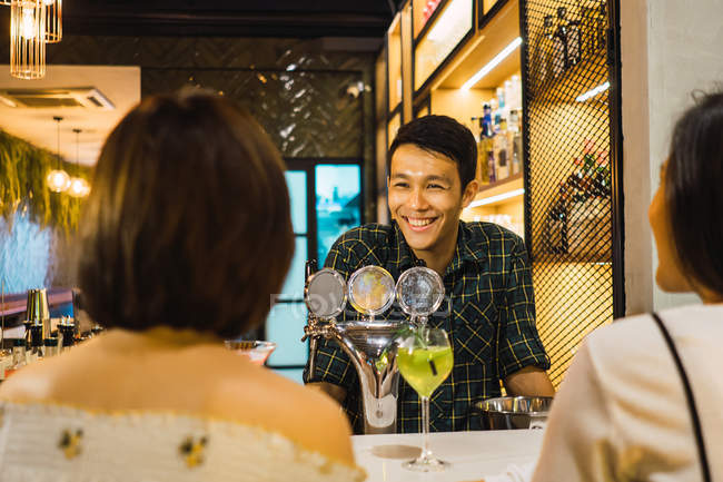 Jeunes amis asiatiques dans un bar confortable — Photo de stock