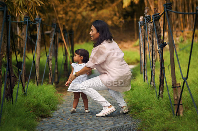 Cute asian mother and daughter in park — Stock Photo