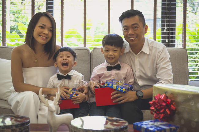Glückliche vierköpfige Familie feiert Weihnachten in ihrem Haus in Singapore. — Stockfoto