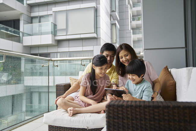Feliz jovem asiático família juntos usando laptop em casa — Fotografia de Stock