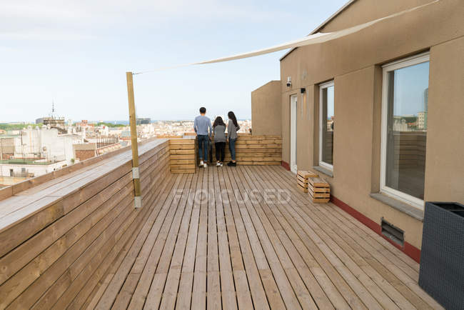 Вид сзади на молодых людей, стоящих вместе на балконе — стоковое фото