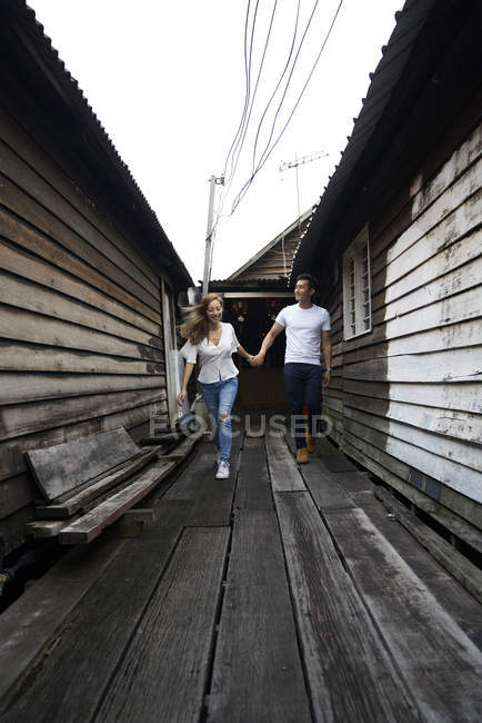 Young attractive asian couple together walking and holding hands — Stock Photo