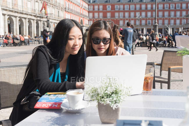 Asian women at a cafe using laptop in Madrid, Spain — Stock Photo