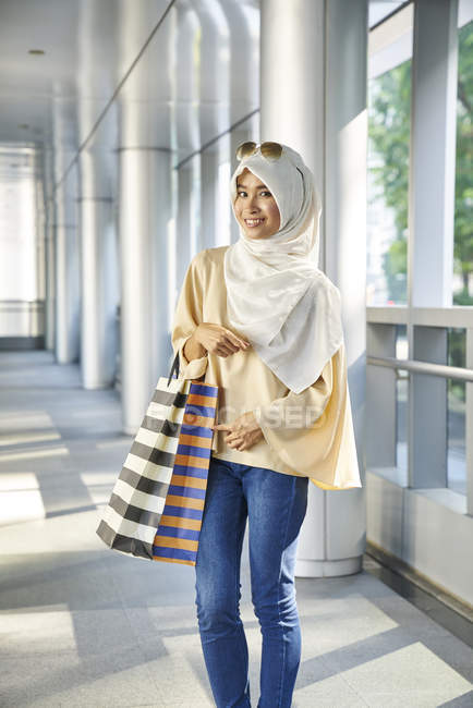 Retrato de una hermosa joven con bolsas de compras - foto de stock
