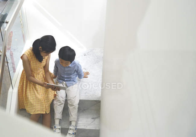 Two cute brother and sister together using tablet — Stock Photo