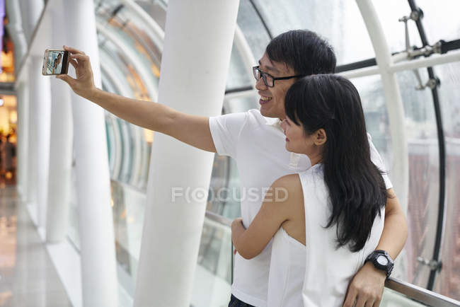 Feliz asiático pareja pasando tiempo juntos y tomando selfie - foto de stock