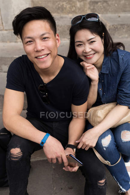 Beautiful young asian couple sitting on steps in Barcelona — Stock Photo
