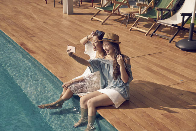 Atraente jovem asiático mulheres tomando selfie perto de piscina — Fotografia de Stock