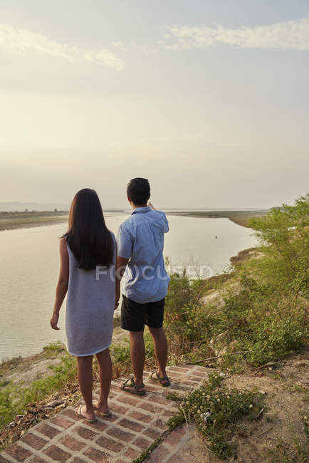 Pareja escalofriante junto a la cornisa del río Irrawady en Bagan, Myanmar - foto de stock