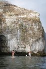Mexico, Banderas Bay, Los Arcos National Marine Park, man and woman paddleboarding, exploring caves and rock formations at sea — Stock Photo