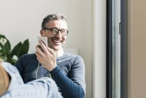 Homme d'affaires utilisant smartphone et écouteurs — Photo de stock