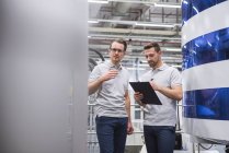 Hombres de pie y hablando en fábrica - foto de stock