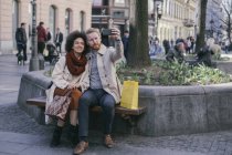 Paar macht Selfie auf Bank — Stockfoto