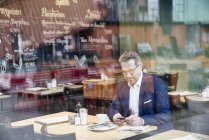 Бізнесмен, за допомогою мобільного телефону в кафе — стокове фото