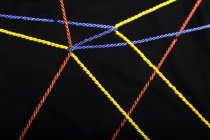 Connected ropes in front of black background — Stock Photo