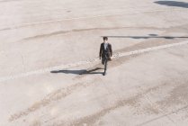 Vista aérea del hombre joven en traje caminando al aire libre - foto de stock