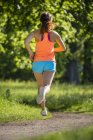 Young woman running in park — Stock Photo