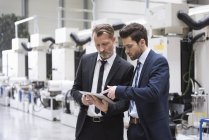Geschäftsleute teilen Tablet — Stockfoto