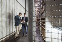 Hommes utilisant la tablette dans l'entrepôt — Photo de stock