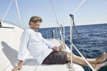 Uomo maturo seduto sulla barca a vela — Foto stock