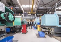 Men walking and talking in factory — Stock Photo