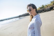Mulher usando óculos de sol na praia — Fotografia de Stock