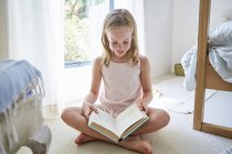 Маленькая девочка и книга для чтения — стоковое фото